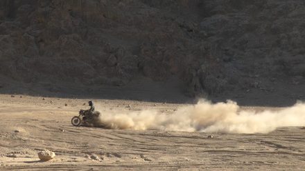 A motorcycle kicking up dust in the desert